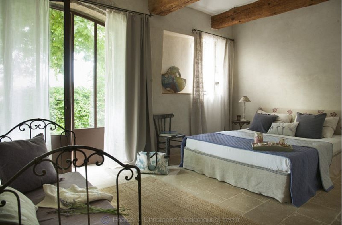 Chambre Bastide — lit fer forgé, poutres apparentes, bleu provençal